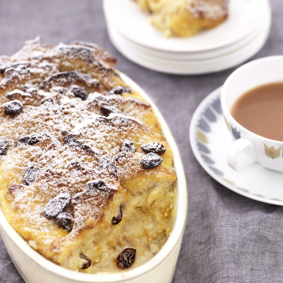 Classic bread and butter pudding, served with a cup of tea for traditional British comfort.