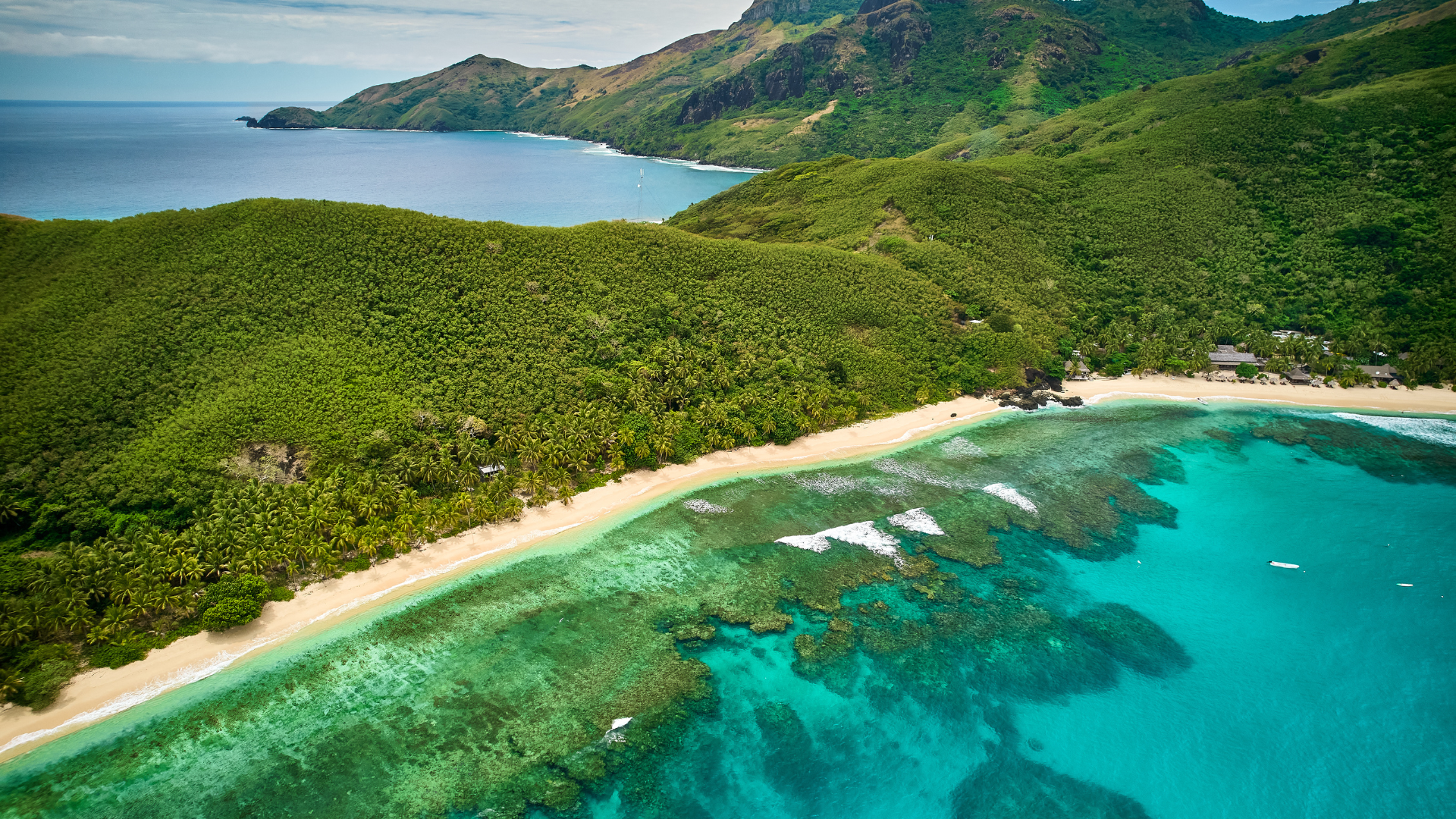 High view of coral reef and mountains on Waya Island in the Yasawa Islands, a volcanic archipeligo located northwest of the Fiji mainland