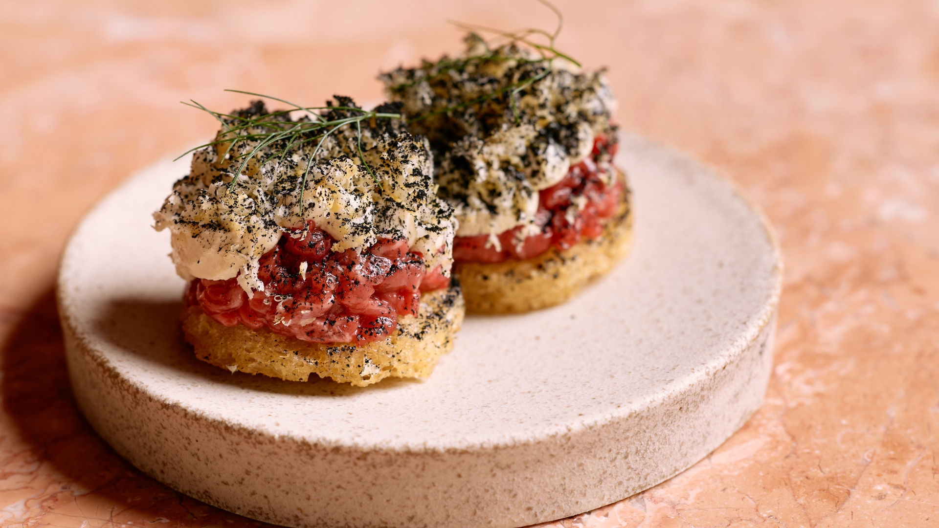 Ruma rooftop's beef encroute features finely chopped raw beef layered with whipped feta cream, fresh horseradish and spring onion dust 