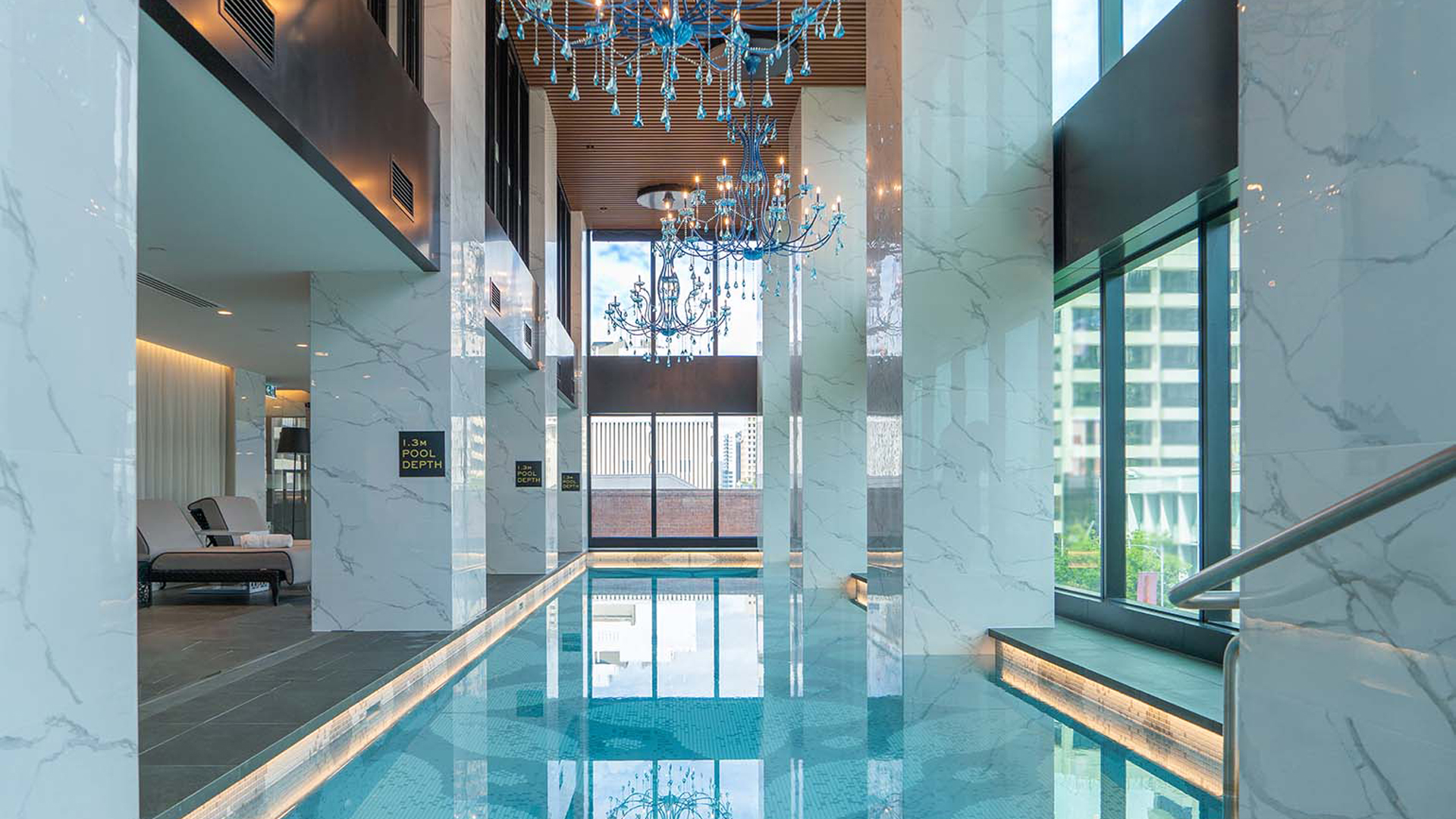 Indoor pool with marble columns and overhanging blue chandeliers at luxury Adelaide hotel, Sofitel Adelaide