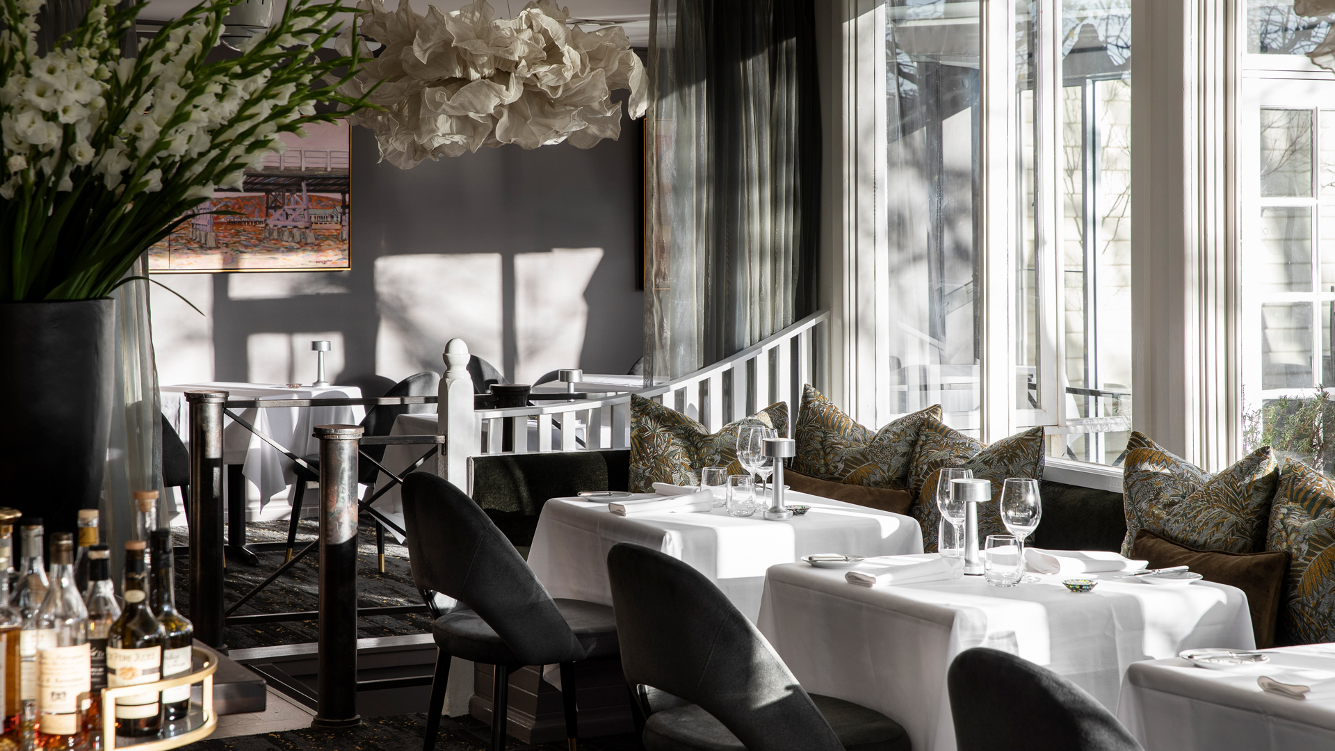 Lake House dining room with white table clothed tables and sunlight through big windows