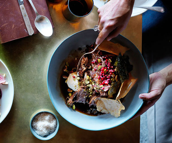 Slowroasted lamb shoulder with pistachios, pomegranate and vine leaves