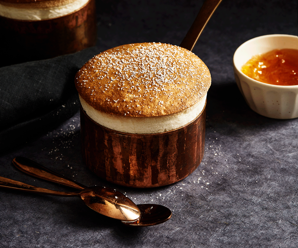 A soufflé dusted with icing sugar and served with burnt orange marmalade, rising a couple of centimetres above the brass tin it was cooked in.